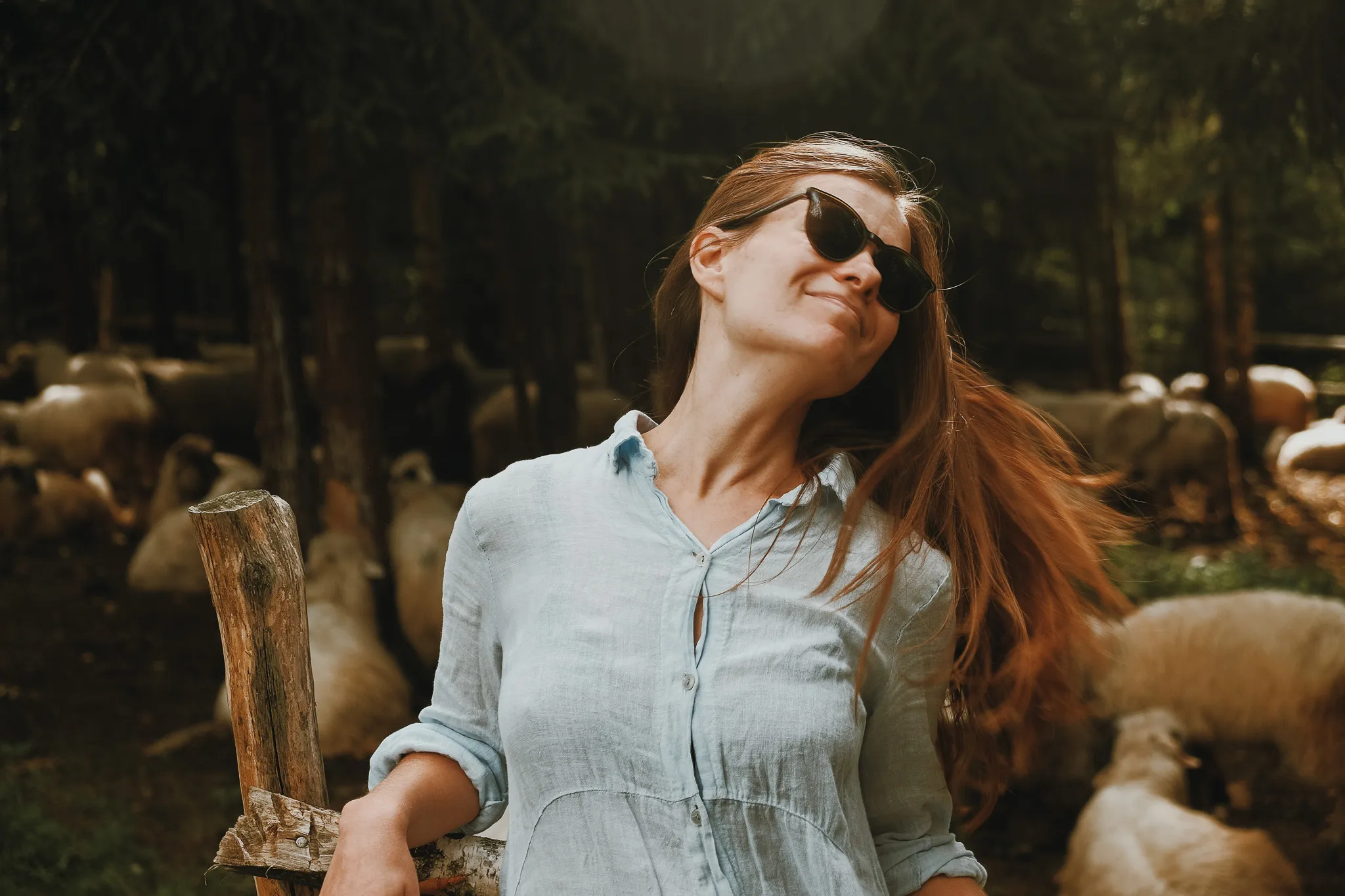 Жінка у сонцезахисних окулярах на індивідуальній фотозйомці на природі, портрет з природним освітленням.