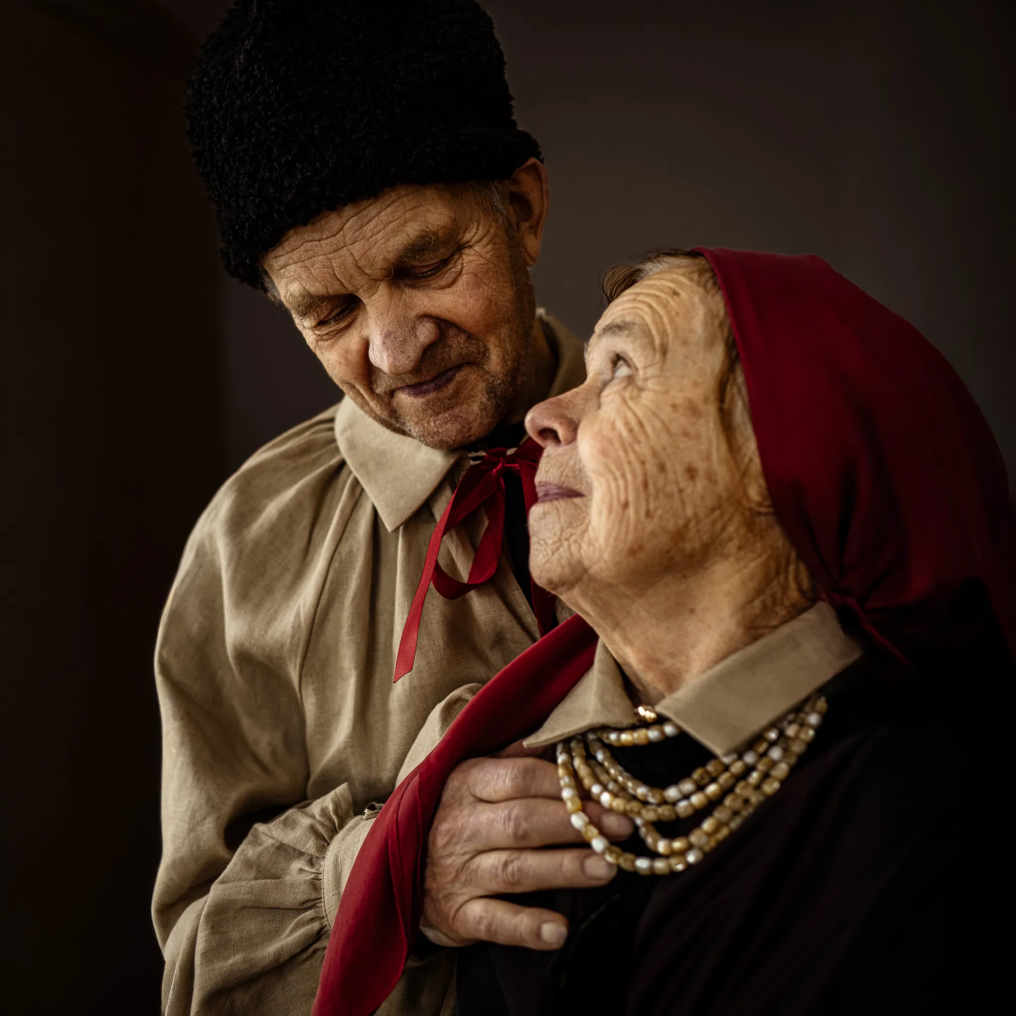 Портрет літньої пари у традиційному одязі, що дивиться один на одного з любов’ю та турботою, Кампейни.